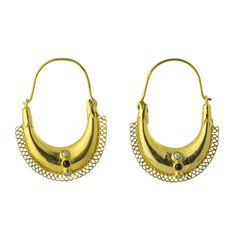 pair of gold toned hoop earrings with filigrees and stones, circa 1950