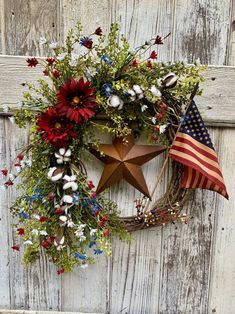 a patriotic wreath with flowers and an american flag