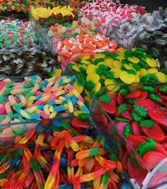 many different colored candies in plastic containers