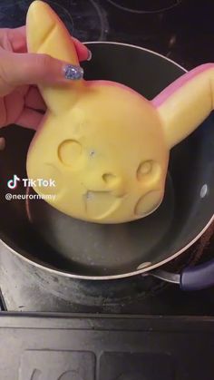 a person is cooking some food in a pan on the stove with it's nose sticking out