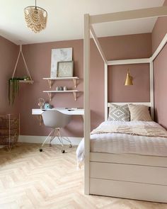 a white bed sitting in a bedroom next to a desk