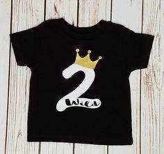 a black t - shirt with the number two on it and a gold crown sitting on top of it