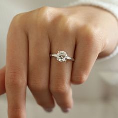 a woman's hand with a diamond ring on it