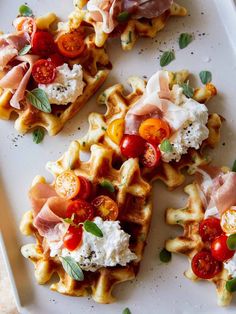 several waffles with various toppings on a white plate, including tomatoes and mozzarella