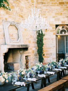 a long table with place settings is set up in front of an old brick building