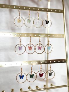 These dangly butterfly hoop earrings are perfect for bringing a pop of color to complete your outfit. Each dainty butterfly charm is made of a pearlescent pewter acrylic, with a gold backing. Choose from peachy pink, turquoise blue, fuchsia pink, light yellow, lavender purple, white, green, ruby red, royal blue, jet black, and charcoal. Matching necklace: https://www.etsy.com/listing/693773136/butterfly-necklace-colorful-gold-pewter ✧ 1 pair of gold plated hoop earrings ✧ 18mm French hook earrin Butterfly Charm Earrings, Butterfly Hoop Earrings, Mariposa Butterfly, Wire Jewelry Rings, Gold Hoop Earring, White Lavender, French Hook Earrings, Pearl Pink, Easy Diy Jewelry