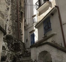 an alleyway with stairs and balconies in the city