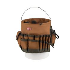 a brown and black bucket filled with lots of pockets on top of a white cup