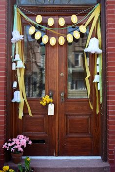 the front door is decorated with yellow and green ribbons, paper lanterns, and flowers