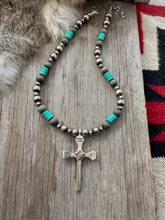 Simple yet powerful, a true labor of love! ~ Limited Quantity ~~ This awesome cross was made by an artist from vintage nails, sand-cast in white bronze sterling silver, hand stamped, and wire wrapped! ~Graced with a Lovely Strand of Navajo Handmade Pearls with Pumpkin Beads and turquoise Handmade by Navajo Artists exclusively for Navajo Pearls Ranch!~Choose Your Length ~Each bead is heavily plated in .925 sterling silver, hand polished & antiqued, creating a perfect handmade Navajo Pearl.You won Traditional Adjustable Cross Jewelry, Vintage Cross Necklace With 8mm Beads, Vintage Cross Necklaces With 8mm Beads, Vintage Cross Jewelry With 8mm Beads, Handmade Southwestern Cross Necklace, Southwestern Handmade Cross Necklace, Artisan Adjustable Cross Jewelry, Spiritual Hand-strung Cross Jewelry, Silver Beaded Cross Jewelry