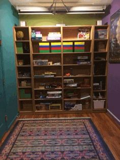 a room with a rug, bookshelf and other items on the floor in it