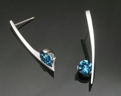 London Blue Topaz - Argentium Silver Earrings - 2458 Make a statement with these modern artisan crafted earrings. A simple, delicate argentium silver design, these earrings were designed to complement the #3458 pendant. Each earring measures 27mm x 7mm, or 1 1/16 x 1/4 inches, and holds a 6 millimeter London Blue Topaz. PLEASE LOOK AT THE MEASUREMENTS CAREFULLY. SOME PHOTOS HAVE BEEN ENLARGED TO SHOW DETAIL, WHILE OTHERS HAVE BEEN MINIMIZED TO FIT THE FRAME. ACTUAL SIZE CANNOT BE DETERMINED FROM Modern Blue Topaz Earrings For Gift, Modern Silver Birthstone Earrings, Modern Silver Earrings With Birthstone, Modern Blue Earrings For Anniversary, London Blue Topaz Earrings, Gemstone Earrings Dangle, Blue Topaz Gemstone, Blue Topaz Earrings, Artisan Earrings