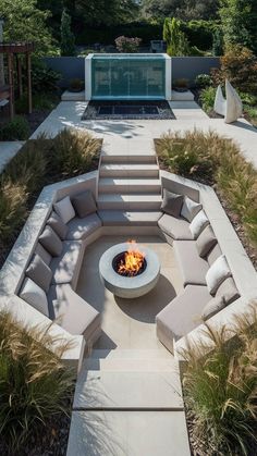 an outdoor fire pit surrounded by grass and bushes