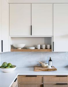 a kitchen with white cabinets and counter tops