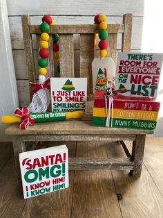 a wooden bench topped with lots of books and christmas decorations next to a sign that says, santa omg i know him i know him