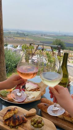 two people toasting with wine at an outdoor table