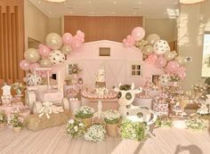 a room filled with lots of pink and white balloons in the shape of farm animals