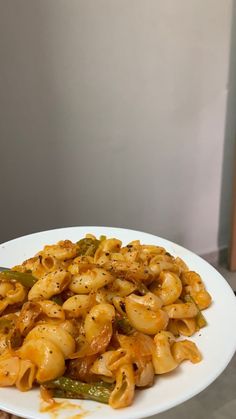 a white plate topped with pasta covered in sauce