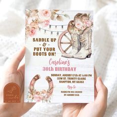 someone holding up a birthday card with boots and flowers on it, in front of a white background