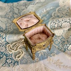 an open box sitting on top of a blue and white cloth covered table with lace