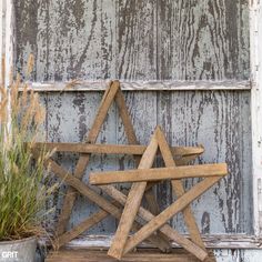 a wooden star sitting next to a potted plant