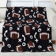 a black blanket with footballs and crosses on it