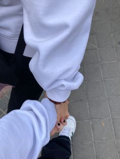 two people holding hands while standing next to each other