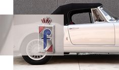 an old white car with the number one on it's front wheel and emblem