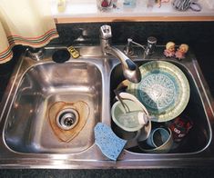 a kitchen sink filled with dirty dishes and clutter