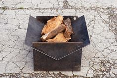 a metal box filled with wood sitting on top of cement