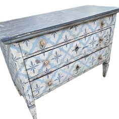 an old blue and white painted dresser with metal knobs on the top, against a white background