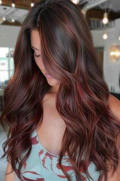 Woman with long, wavy, chestnut brown hair looking down. Deep Red With Caramel Highlights, Brown Hair Mahogany Highlights, Red Tones Balayage, Red Lowlights For Brunettes, Brown To Burgundy Balayage, Red Dimensional Hair, Brunette Red Ombre, Burgundy Balayage Brunettes, Brown And Red Balayage