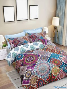 a bed covered in colorful bedspreads and pillows