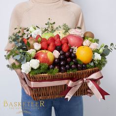 a woman holding a basket filled with fruit