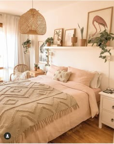 a bedroom with a bed, chair and plants on the wall above it is decorated in neutral colors