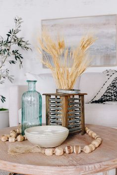 a table topped with vases filled with dried flowers and other decorative items on top of it