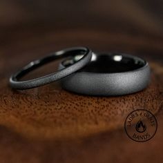 two wedding rings sitting on top of a wooden table