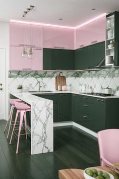 a pink and green kitchen with marble counter tops