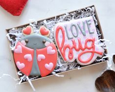 two decorated cookies in a box with love bugs on them and the words love bug