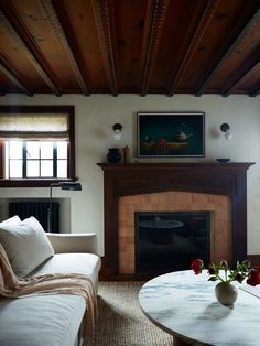 a living room filled with furniture and a fire place in front of a painting on the wall