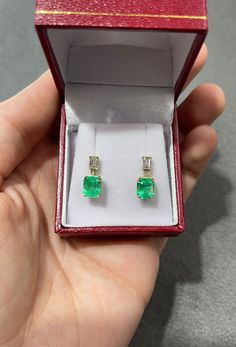 Displayed is a stunning pair of emerald and diamond, dangle earrings. Two gorgeous Colombian emerald-emerald cuts totaling a full 3.15-carats, accented by two diamond baguettes. Set in simple prong settings, allowing for the emeralds and diamonds to be shown in full view. The earth mined, green emeralds have a desirable lush green color with excellent qualities. The perfect drop and dangle earrings. Setting Style: Four Prong Setting Material: 18K Yellow Gold Weight: 2.2 Grams Main Stone: Emerald Emerald And Diamond Drop Earrings, Elegant Green Emerald Diamond Earrings, Formal Baguette-cut Emerald Earrings, Elegant Green Emerald-cut Diamond Earrings, Colombian Emerald Earrings, Luxury Green Emerald-cut Earrings, Diamond Baguette, Earrings Emerald, Emerald Earrings Studs