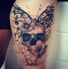 a skull with flowers on it's head is shown in black and grey ink