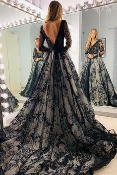 a woman in a black and white dress looking at herself in front of a mirror