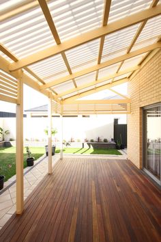 a wooden deck with potted plants on the side and an awning over it