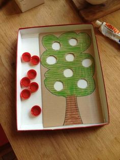 a paper plate with buttons in the shape of a tree on top of a wooden table