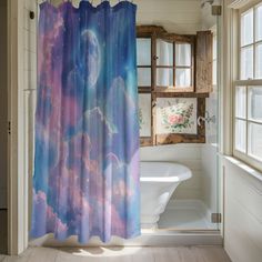 a bathroom with a shower curtain that has an image of the moon and stars on it