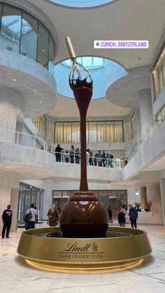 a woman is standing in front of a fountain with a clock on it's side