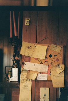 several pieces of paper are attached to a wooden paneled wall in an old house