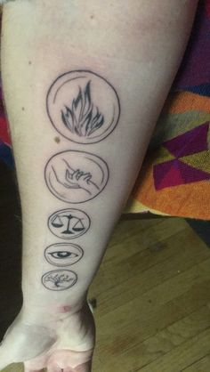 a person with a tattoo on their leg that has five different symbols in each circle