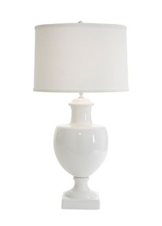 a white table lamp with a white shade on it